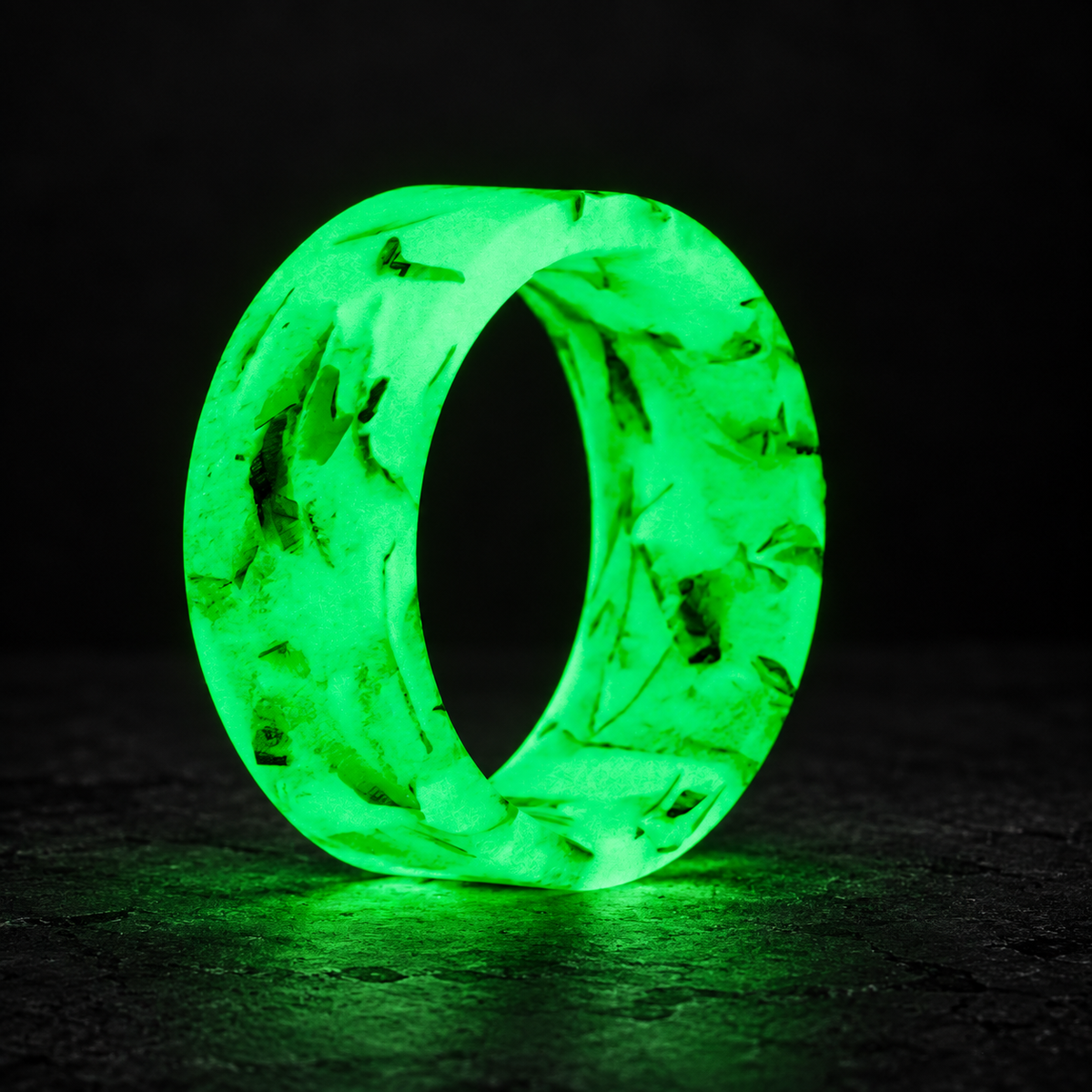 Benjamin's Glow shredded money ring glowing green on a dark studio background