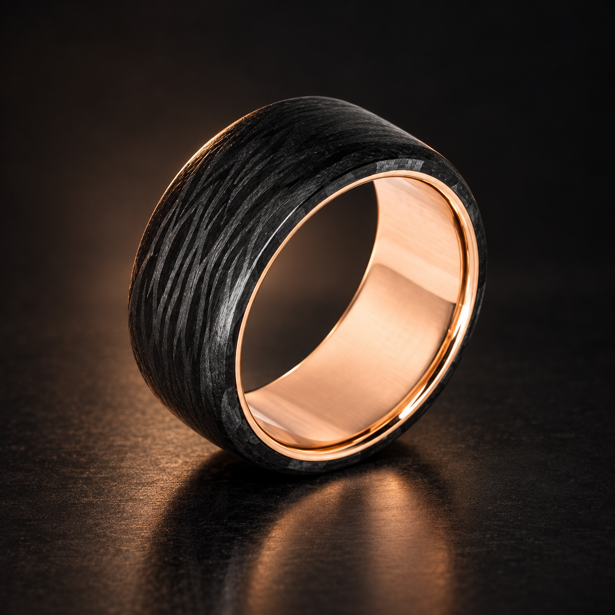 Carbon Fiber and Gold Ring handcrafted in forged carbon fiber and solid rose gold on a dark studio background