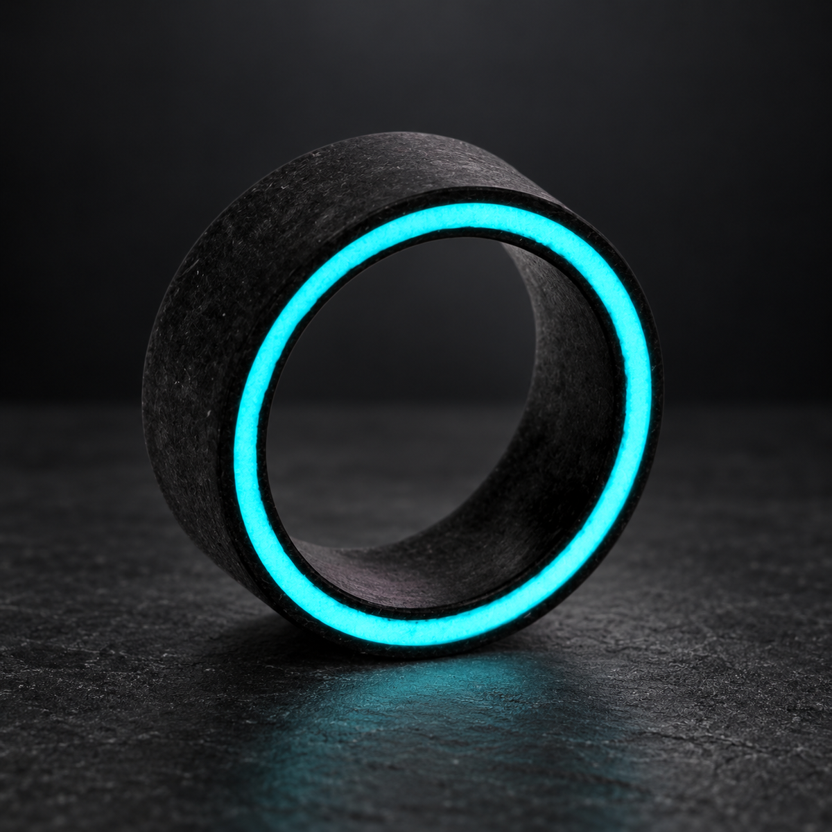 Forged carbon fiber side glow ring on a dark studio background